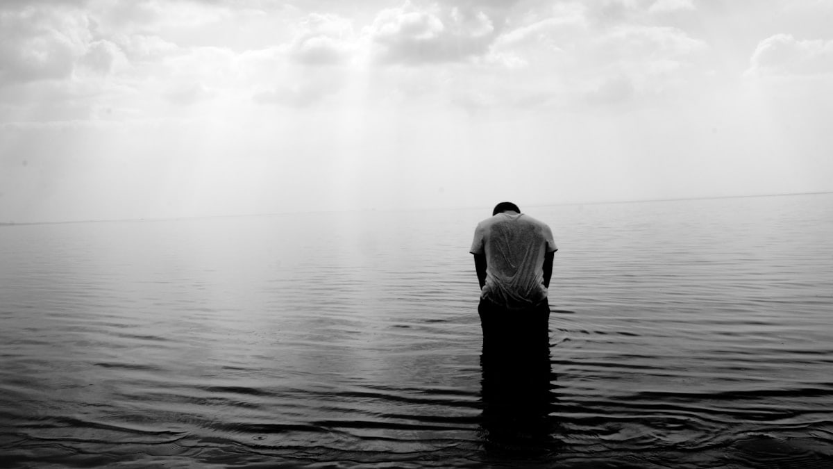 grayscale photography of person on beach